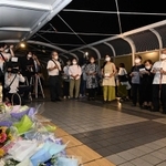 歩道橋にある慰霊碑「想（おもい）の像」前で、市民有志らがレクイエム「さよならの花火」を合唱した。事故の翌年に声楽家の故・有宗政忠さんが結成した合唱団「きらぼし」は、昨年の２０年を節目に解散。有志が活動を続ける＝２１日夜、明石市大蔵海岸通１（撮影・坂井萌香）
