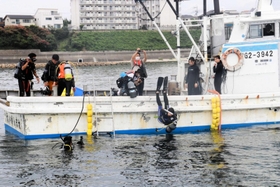 漁船で海に潜る準備を進めるダイバー＝江井島沖