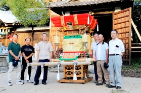 地域に寄贈された手作りの布団太鼓と安藤政彦さん（左から３人目）＝明石市大久保町大久保町