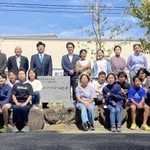 式典後に石碑を囲んで記念撮影する子どもら＝二見小学校