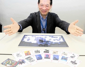 プラネタリウム機を紹介したトランプと、明石市立天文科学館にあるプラネタリウム機のジグソーパズル＝明石市人丸町