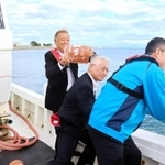 タコつぼを投入する泉房穂明石市長（中央）ら＝二見沖