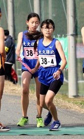 女子・大久保北の３区浅山藍琉選手（左）からたすきを受け取る４区加古瑞季選手＝豊岡市日高町（撮影・長嶺麻子）