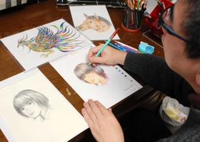 創作中の田寺さん。「配色のバランスを考えながら描いています」＝明石市