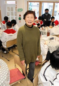 中学生と高齢者を訪問した師走。円卓の間に立つ松本茂子さん＝明石市西明石南町２