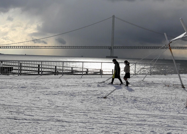 大蔵海岸公園で雪の中を歩く子どもたち＝明石市大蔵海岸通２
