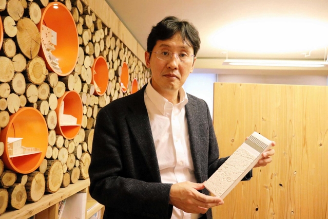 壁の断熱材を紹介する松尾和也さん＝明石市西明石北町１