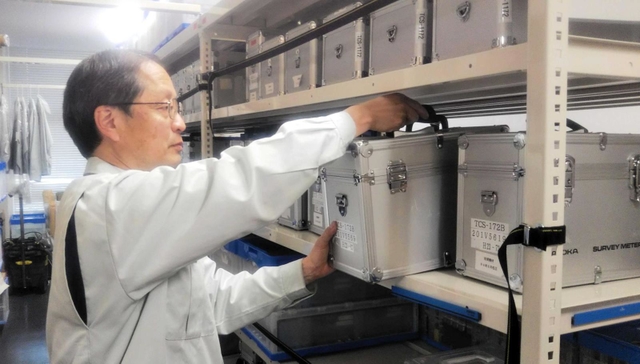 福島県原子力安全対策課の倉庫で資機材の整理にあたる丸谷聡さん＝福島市内