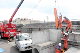 クレーンを支点にロープで担架をつり上げる訓練＝明石市大観町