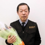 錦城高校で講演した際、退職祝いとして花束を受け取った大谷誠教諭＝明石市明南町３