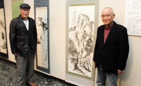 中島さんの作品「樵の楽日」（右）のそばに立つメンバー＝明石市立勤労福祉会館