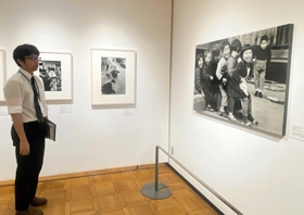 おしくらまんじゅうで遊ぶ子どもの笑顔を捉えた写真などが並ぶ＝明石市立文化博物館