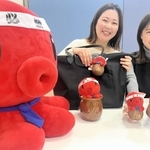 「パパたこ」と「ひっぱりだこ飯」のコラボぬいぐるみストラップを手にＰＲする明石観光協会職員＝明石市東仲ノ町