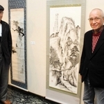 中島さんの作品「樵の楽日」（右）のそばに立つメンバー＝明石市立勤労福祉会館