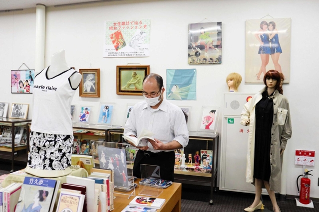 昭和の女性ファッションに関する本やグッズが並ぶ＝県立図書館