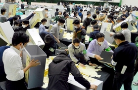 明石市長選と市議選の開票作業を進める市職員＝４月２３日夜、明石市大久保町松陰