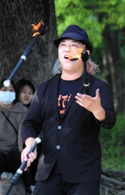 炎のジャグリングを披露するひろとさん。「大道芸は練習すればするほどうまくなれる」＝県立明石公園