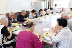 和気あいあいと給食を楽しむ参加者たち＝魚住コミュニティ・センター