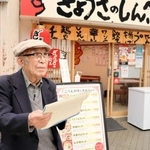 魚の棚商店街でスケッチする伊藤太一さん＝明石市本町１