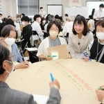 タウンミーティングで意見を交わす参加者ら。丸谷聡子市長（中央右）も各グループを巡った＝明石市東仲ノ町