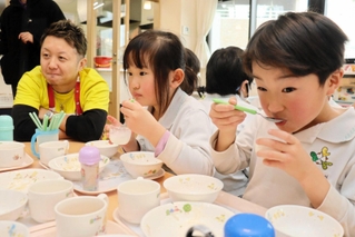 明石市出身のシェフ小沢亮吾さん（左）が作ったツバメの巣のデザートを食べる園児＝明石市大久保町大久保町