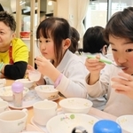 明石市出身のシェフ小沢亮吾さん（左）が作ったツバメの巣のデザートを食べる園児＝明石市大久保町大久保町