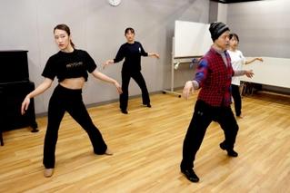 蔡暁強さん（右から２人目）からダンスの指導を受けるオーディションで選ばれた参加者たち＝明石市東仲ノ町