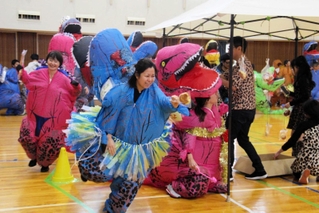 ティラノサウルスの着ぐるみを着てパン食いリレーを楽しむ参加者＝いずれも明石市立勤労福祉会館
