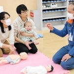 講師（右）から乳幼児の心肺蘇生法などを学ぶ参加者＝明石市大明石町