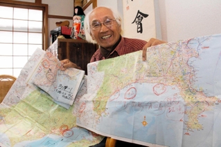 旅で使った地図を見せる谷上満夫さん＝神戸市西区