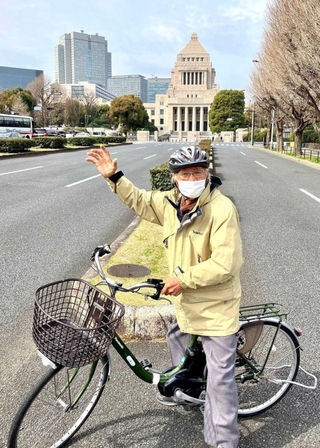 国会議事堂前で記念撮影する谷上満夫さん＝東京都千代田区（谷上直也さん提供）