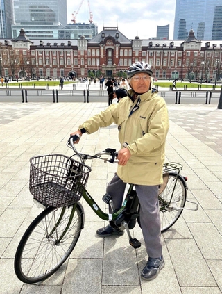東京駅前で自転車にまたがる谷上満夫さん（谷上直也さん提供）