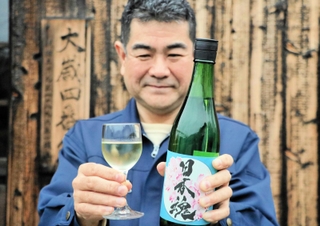 ワイングラスに入った「日本魂　純米生　水酛スペシャル２」を手にする杜氏の中村裕司さん＝江井ヶ嶋酒造