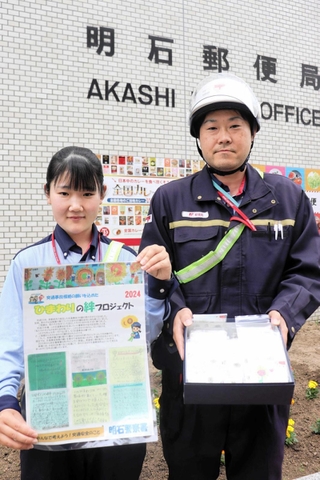 明石署からひまわりの種を譲り受けた明石郵便局の局員たち＝明石市樽屋町