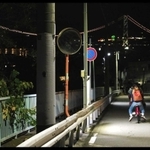 明石市東朝霧丘の坂道で撮影された映画の一場面。奥に明石海峡大橋が輝く（（Ｃ）ノブ・ピクチャーズ）