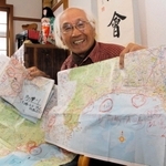旅で使った地図を見せる谷上満夫さん＝神戸市西区