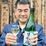 ワイングラスに入った「日本魂　純米生　水酛スペシャル２」を手にする杜氏の中村裕司さん＝江井ヶ嶋酒造