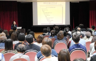 ギャンブル依存症や会の取り組みについて語る田中紀子さん（左奥）＝明石市立勤労福祉会館