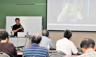 講演する山嵜清張さん（左奥）＝大蔵コミセン