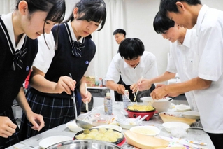 たこ焼きと明石焼きを焼く生徒たち＝明石商業高校