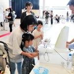 熱中症予防ブースで湿度体感機を体験する親子＝あかし市民広場