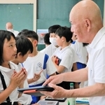 大江平治元校長（右）から作品のアドバイスを受ける児童ら＝江井島小学校