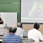 講演する山嵜清張さん（左奥）＝大蔵コミセン