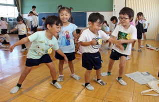 新聞紙で作ったスリッパを履いて喜ぶ園児たち＝高丘西幼稚園