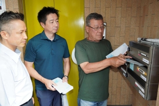 迷惑行為への注意を呼びかけるチラシを配る鍛治屋町自治会の田中良夫会長（右）ら＝明石市鍛治屋町