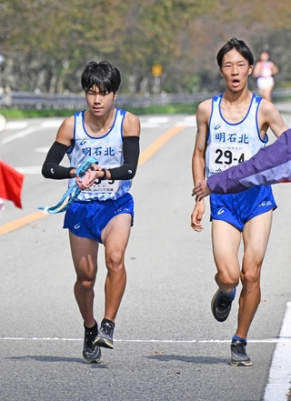 男子・明石北の４区和田朋樹選手（右）からたすきを受け取る５区田上大智選手＝丹波篠山市内（撮影・風斗雅博）