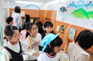 キャラバンカーの中で絵本を選ぶ子どもたち＝貴崎小学校