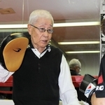 生徒のミット打ちを受ける吉田欽哉会長＝明石市荷山町