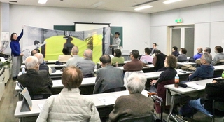 長崎に落とされた原子爆弾について、実物大の布を使った説明に耳を傾ける参加者ら＝明石市立勤労福祉会館
