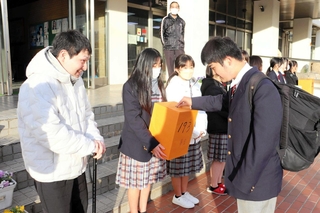 校舎前で寄付を呼びかける山本育海さん（左）と生徒会のメンバーら＝明石市魚住町清水